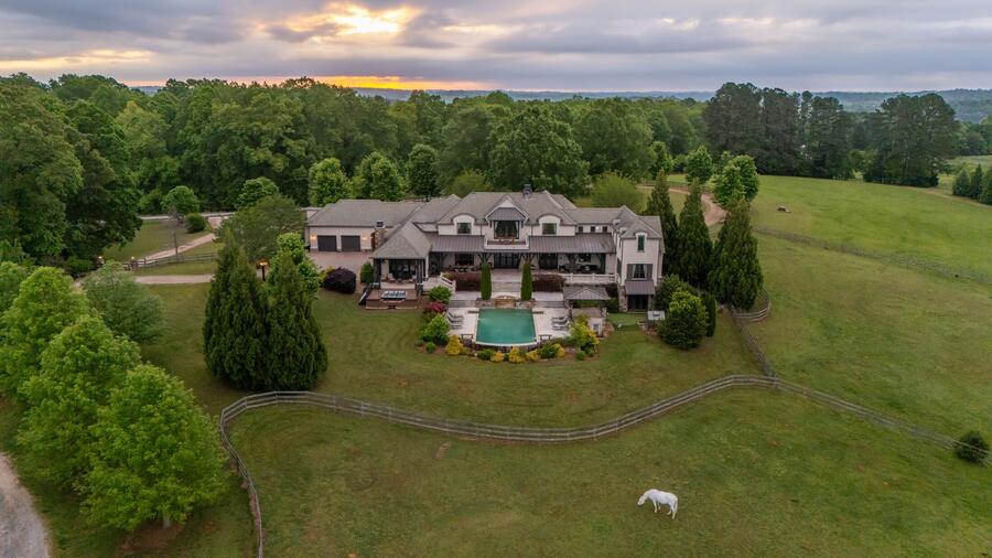 The residence above its pastures at dusk